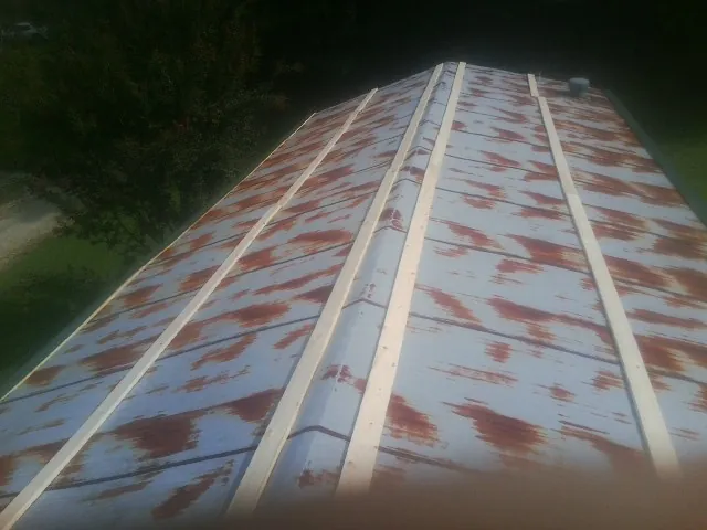 Rusted metal roof panels with new wood purlins before replacement — Storm Damage Roof Repair in Drummond by Roofing Brothers