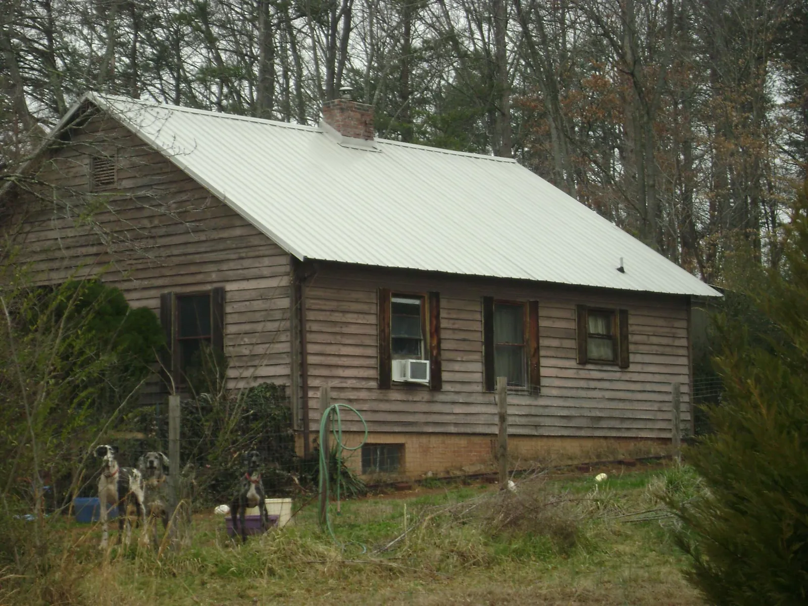 White metal roof on an old wood sided farmhouse, from a Metal Roof Installation job in Drummond